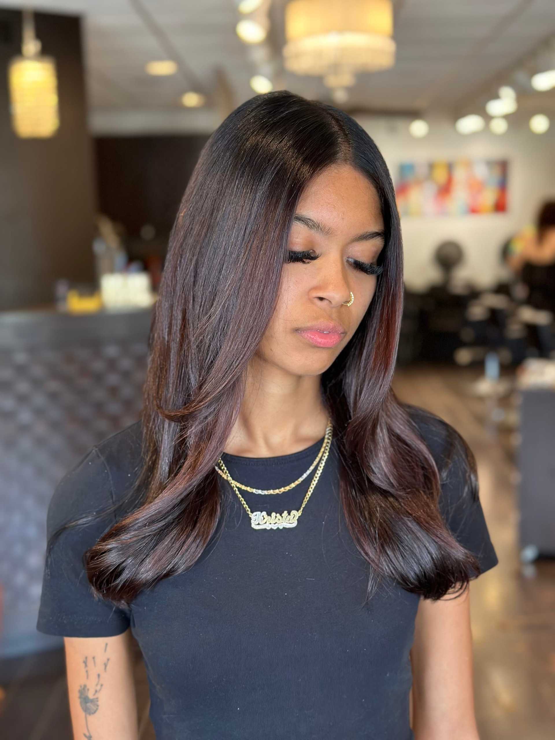 Portrait of a woman in a salon with long, smooth, dark hair.