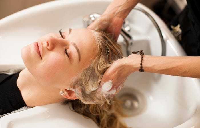 Woman enjoying a hair wash at a salon sink.