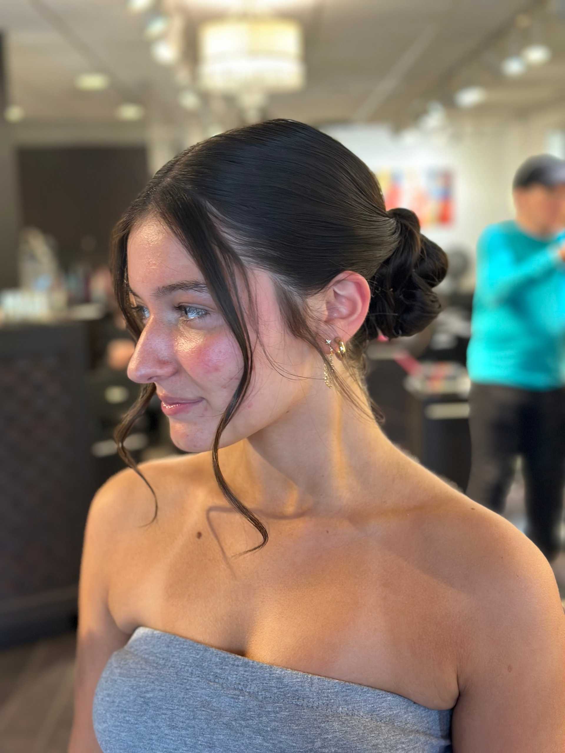 Young woman with elegant updo hairstyle in a salon setting.