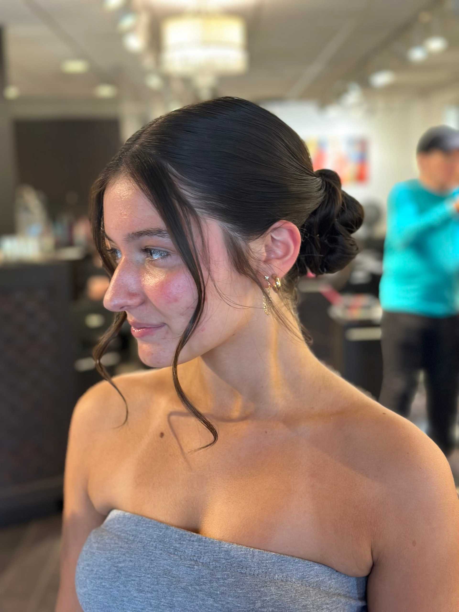 Young woman with elegant updo hairstyle in a salon setting.